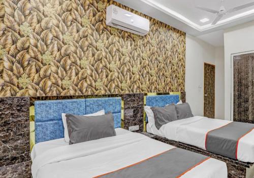 two beds in a room with a wall at HOTEL Sarovar in Ahmedabad