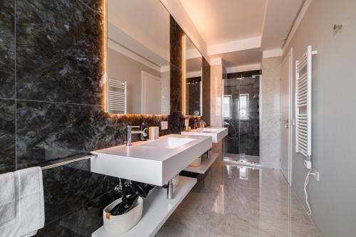 a bathroom with two sinks and a large mirror at Urbanicooh Cavour Rooms&Suite in Bologna