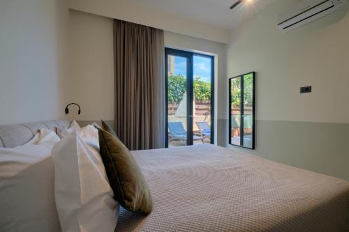 a bedroom with a bed and a large window at Mariette Rhodes Urban Suites in Rhodes Town
