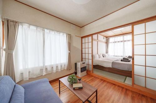 a living room with a bed and a large mirror at Sapporo Nakajima Parkhouse in Sapporo
