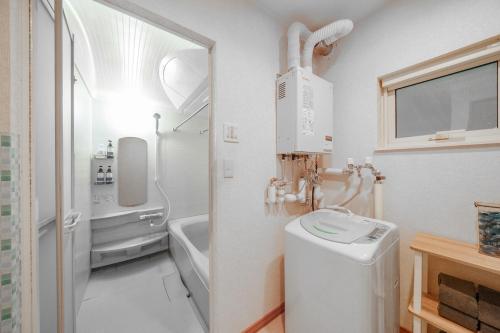 a white bathroom with a toilet and a sink at Sapporo Nakajima Parkhouse in Sapporo