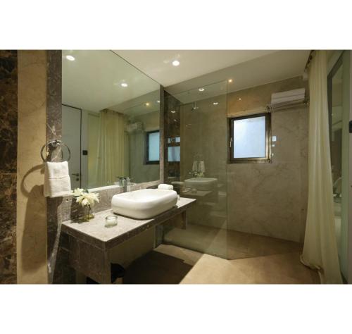 a bathroom with a sink and a shower at Hotel Prince, Bhuj in Bhuj