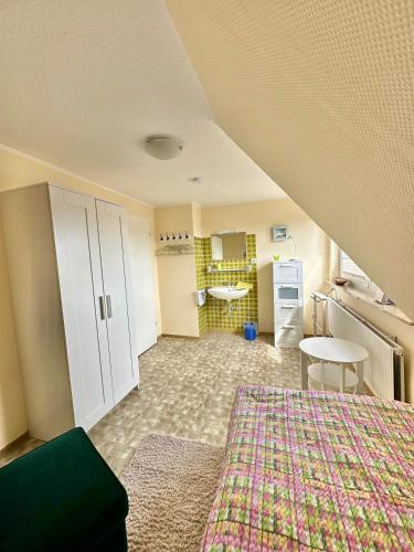 an attic room with a bed and a kitchen at Ferienwohnung Janssen in Borkum