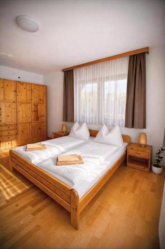 a bedroom with a large bed with white sheets at Salzleckerhof in Lambach