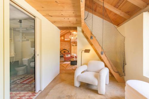 a white chair in a room with a staircase at Eclectic Monte Laginha Alentejo in Aldeia do Cano
