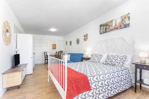 a bedroom with a white bed and a crib at Las Palmeras 2 in Güimar