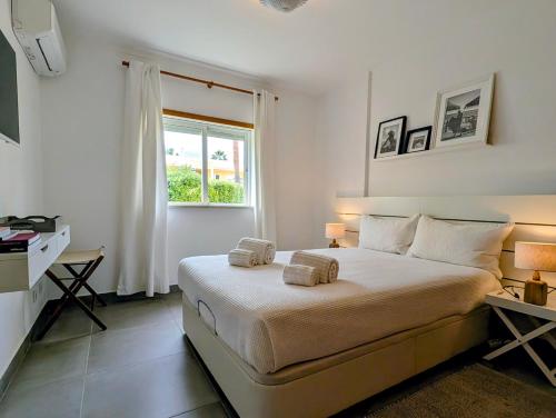 a bedroom with a bed with two towels on it at 1A The Apartment in Albufeira