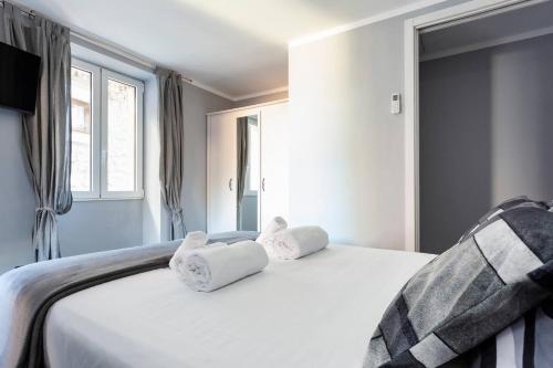 a bedroom with a white bed with towels on it at Il nido di Argegno in Argegno