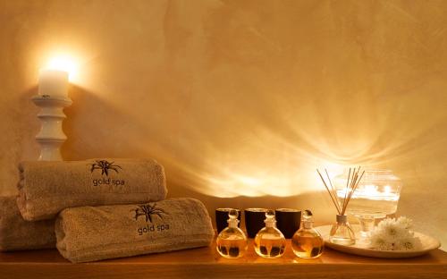 a table with towels and a candle and three wine bottles at Andromeda Villas & Spa Resort in Imerovigli