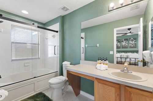 a bathroom with a toilet and a tub and a sink at 25% Off 3BR Disney Area Villa in Davenport