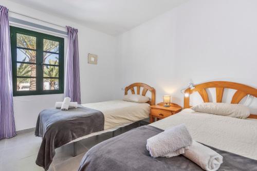 a bedroom with two beds and a window at Heiwa Apartment With Pool in Costa Calma