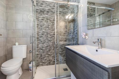 a bathroom with a toilet and a sink and a shower at Heiwa Apartment With Pool in Costa Calma