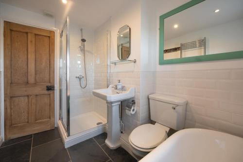 a bathroom with a toilet and a sink and a shower at The Old Ale House in Craster