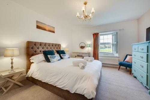 a bedroom with a large bed and a blue dresser at The Old Ale House in Craster