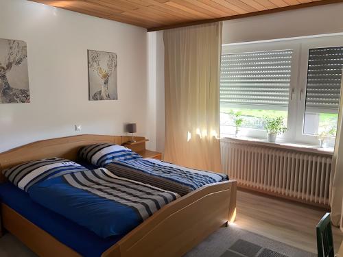a bedroom with a bed with blue sheets and a window at Ferienwohnung Wartehof in Bad Emstal