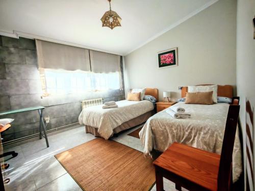 a bedroom with two beds and a window at Apartamento en las afueras in Ribadeo