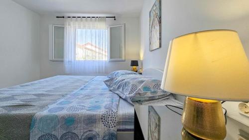 a bedroom with a bed and a table with a lamp at Ivanka A2 in Dajla