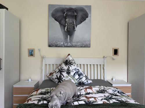 a bedroom with an elephant painting on the wall at Appartement am Teich 2 in Krefeld