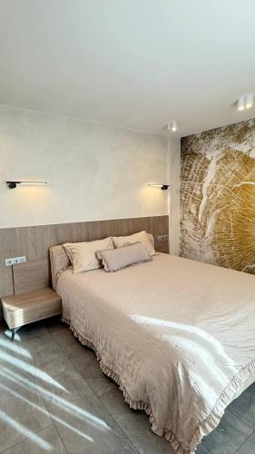 a bedroom with a large bed with a brick wall at Апартамент АТЕА in Kavarna