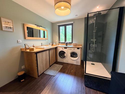 a bathroom with a sink and a washing machine at Ferme du Bien Hêtre Gîte Cosy in Saint-Arnoult
