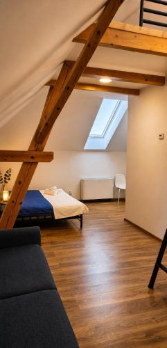 a loft with a bed and a couch in a room at Centrum Rosenbaum in Beroun