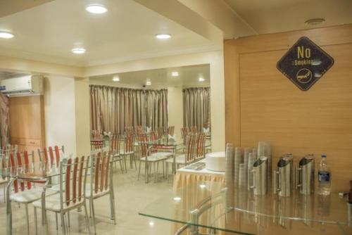 a restaurant with tables and chairs and a no smoking sign at Hotel Orchard in Pune