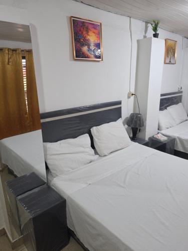 a bedroom with two beds and a picture on the wall at Ypane Residencial in Ypane