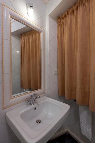 ein Badezimmer mit Waschbecken und Spiegel in der Unterkunft Hotel Astoria in Coimbra