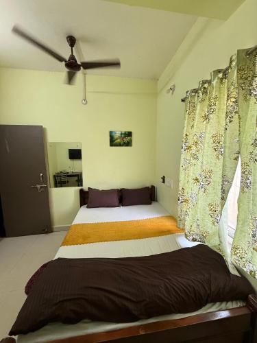 a bedroom with a bed and a ceiling fan at Sunlight Premium in Bhubaneshwar
