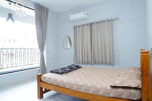 a bedroom with a bed and a window with a balcony at Sukruthi service apartment 3BHK in Mangalore