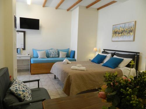a bedroom with a large bed and a couch at Perakis Apartments in Hydra