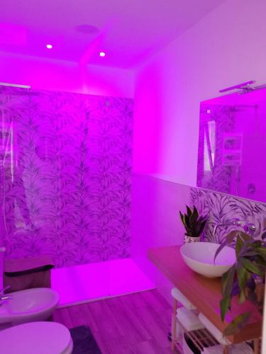 a pink bathroom with two sinks and a mirror at La casa di mamma in Monopoli