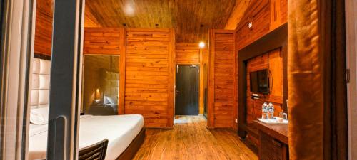 a bedroom with wooden walls and a bed in a room at Eden Resort By Live Inn in Lansdowne