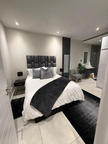 a bedroom with a large bed with a black and white comforter at The paramount houghton Zayna in Johannesburg