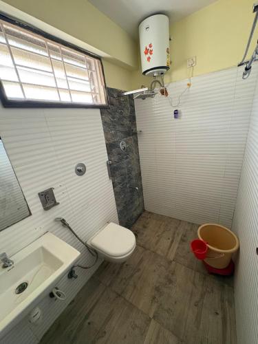 a bathroom with a toilet and a sink at Restora Amaze Inn in Bangalore