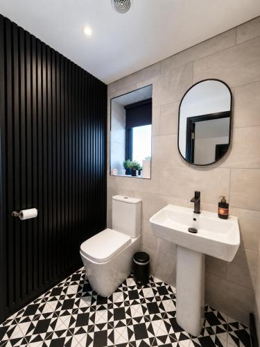 a bathroom with a sink and a toilet and a mirror at Holly Tree Luxury Lodge in Skipwith