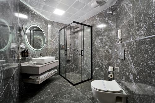a bathroom with a shower and a toilet and a sink at Elysee Beach Hotel in Alanya