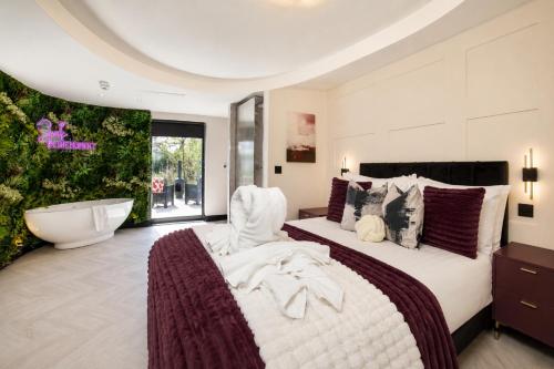 a bedroom with a large bed and a bath tub at Holly Tree Luxury Lodge in Skipwith