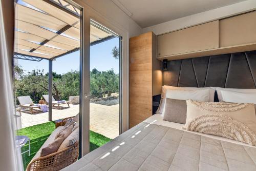 a master bedroom with a bed and a balcony at Olive Spa Oasis with Private Jacuzzi and Summer Kitchen in Orasac