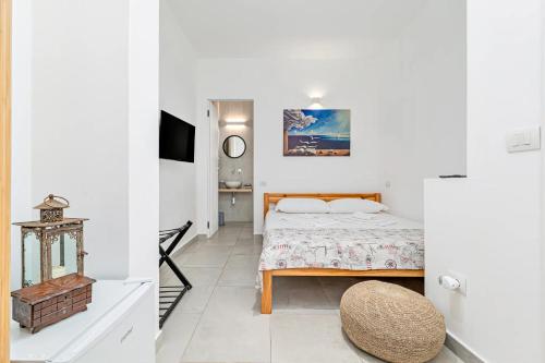 a bedroom with a bed in a white room at Ghjlgolu Suites - Essential Stay in Monte Petrosu