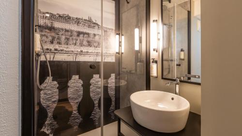 a bathroom with a sink and a glass shower at Campanile PRIME - Le Blanc Mesnil in Le Blanc-Mesnil