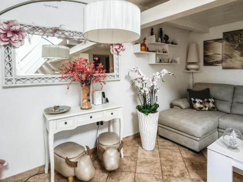 a living room with a couch and a table with flowers at Magic DaLu House in Olbia