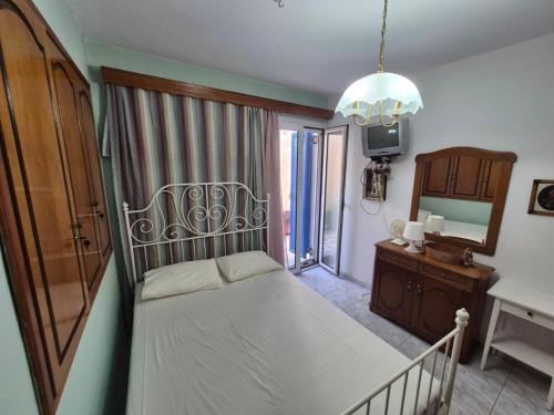 a bedroom with a bed and a dresser and a mirror at Dimitra House in Parga