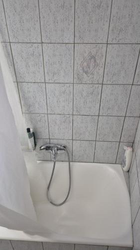 a white bath tub with a shower in a bathroom at Dimitra House in Parga