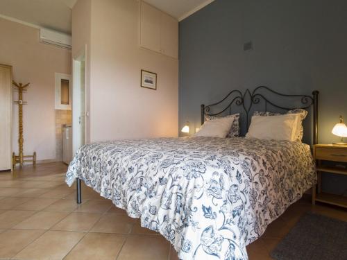 a bedroom with a bed with a blue and white comforter at Corfu Green Escape in Achílleion