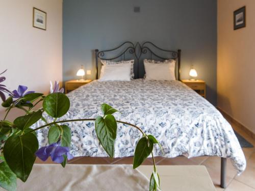 a bedroom with a bed with a blue and white comforter at Corfu Green Escape in Achílleion
