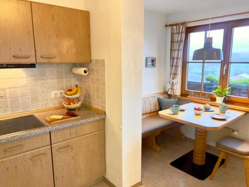 a kitchen with a table and a small table and a window at Gästehaus Alpenruh in Fischen