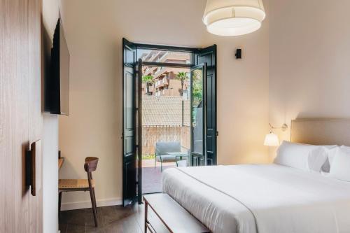 a hotel room with a bed and a balcony at La Chipirona Hotel in Valencia