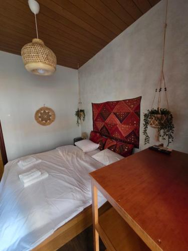 a bedroom with a white bed and a wooden table at Sherlock Home in Komotini