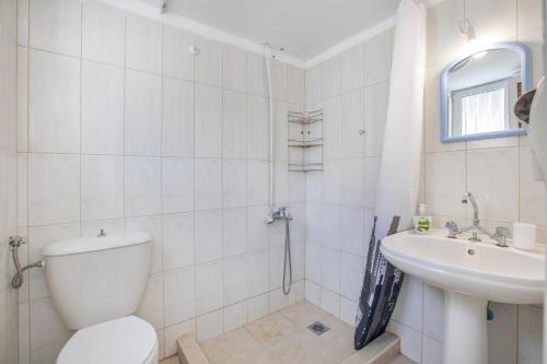 a white bathroom with a toilet and a sink at Villa Sissy in Kerames